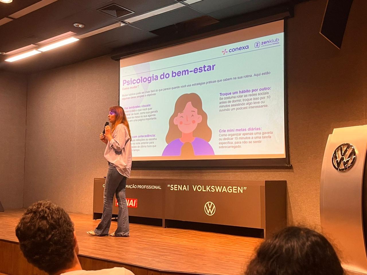 Ana falando ao microfone em uma ação na Volkswagen